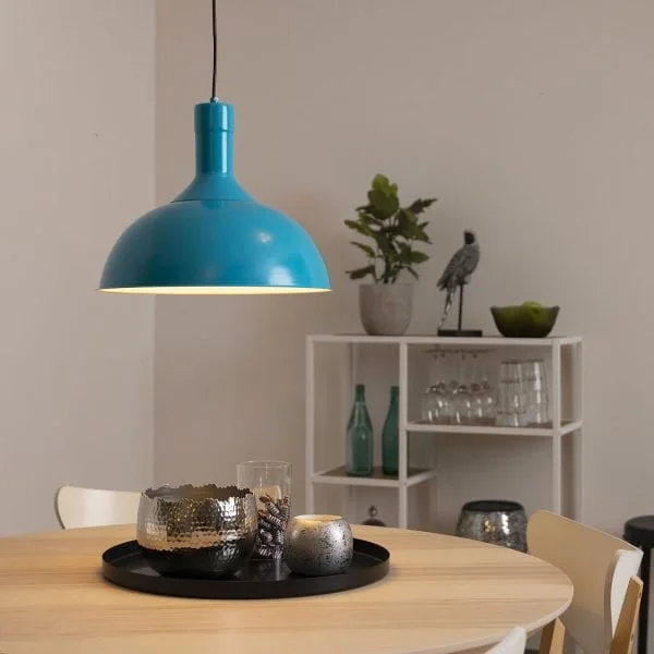 Turkoosi riippuvalaisin pyöreän ruokapöydän päällä.