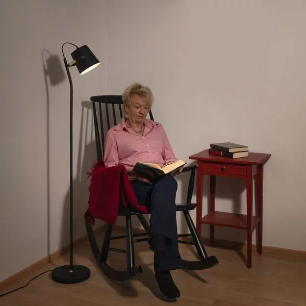Musta lattiavalaisin tuolin vieressä lukuvalona.