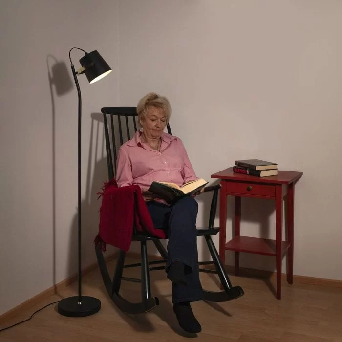 Musta lattiavalaisin tuolin vieressä lukuvalona.