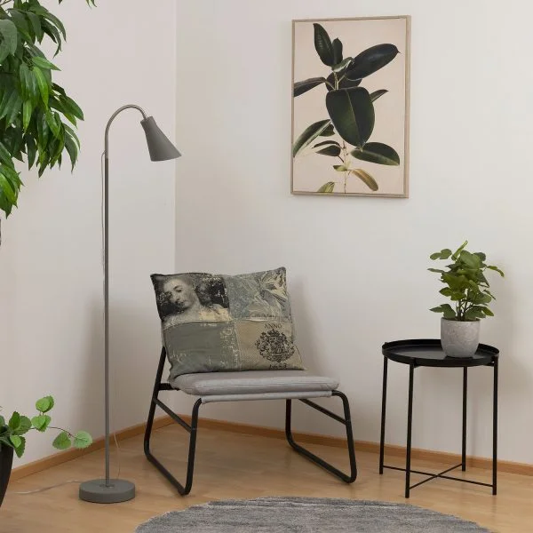 Harmaa lattiavalaisin tuolin vieressä lukuvalona.