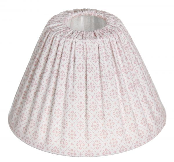 Lampunvarjostin jossa on valkoisella pohjalla vaaleanpunainen kukkakuvio. Varjostin on materiaaliltaan kangasta.