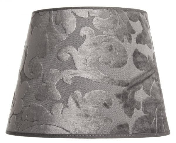 Lampunvarjostin jossa on harmaalla pohjalla ornamentti kuvio. Varjostin on materiaaliltaan laminoitua kangasta.
