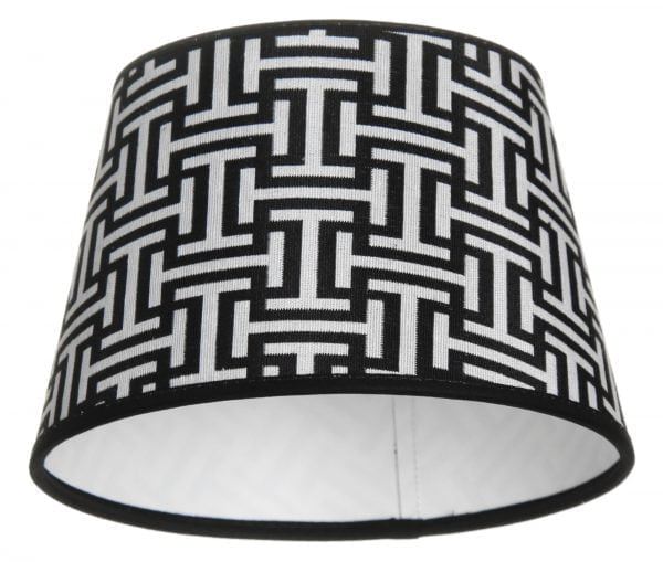 Lampunvarjostin jossa on mustavalkoinen geometrinen kuvio. Varjostin on materiaaliltaan laminoitua kangasta.