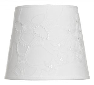Lampunvarjostin jossa on valkoisella pohjalla kukka kuvio. Varjostin on materiaaliltaan laminoitua kangasta.