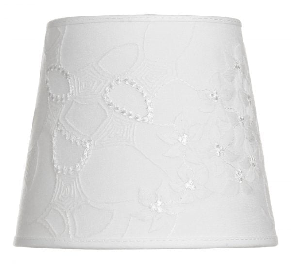 Lampunvarjostin jossa on valkoisella pohjalla kukka kuvio. Varjostin on materiaaliltaan laminoitua kangasta.