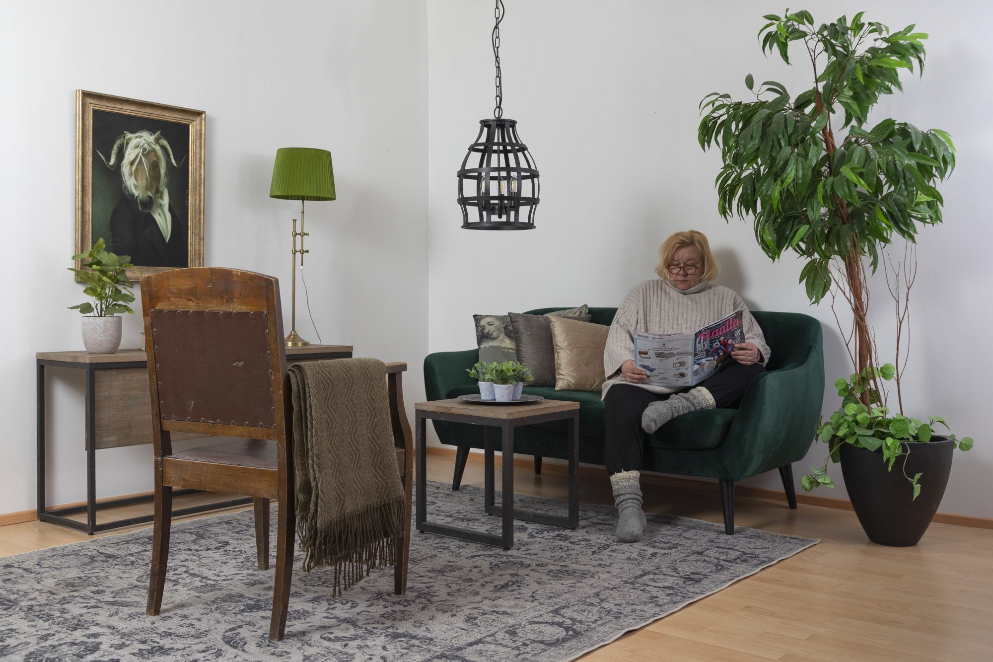 Olohuoneen sisustus, jossa on musta Yvonne kattovalaisin, sekä Rimini pöytävalaisin vihreällä Cleo varjostimella.