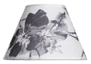 Lampunvarjostin jossa on vaalealla pohjalla musta kukka kuvio. Varjostin on materiaaliltaan laminoitua kangasta.