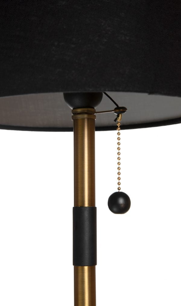 Metallinen pöytävalaisin. Pöytälamppu on väriltään antiikki messinki. Musta varjostin on laminoitua kangasta.