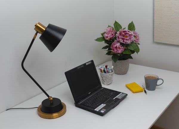 Työpöytä, jolla on musta Gener-P -pöytävalaisin, läppäri, viherkasvi ja keltaisia lappuja.