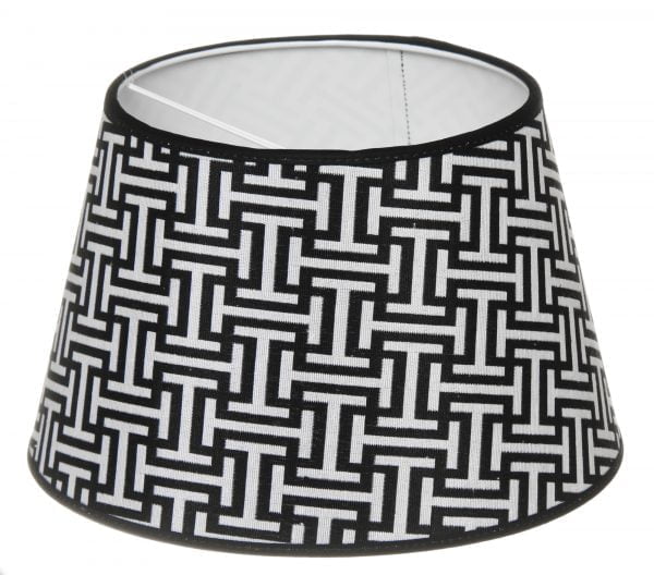 Lampunvarjostin jossa on mustavalkoinen geometrinen kuvio. Varjostin on materiaaliltaan laminoitua kangasta.