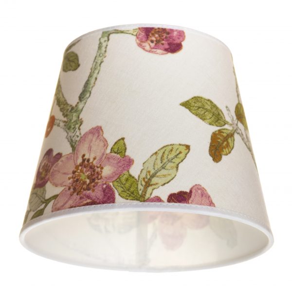 Lampunvarjostin jossa on vaalealla pohjalla kukka kuvio. Varjostin on materiaaliltaan laminoitua kangasta.