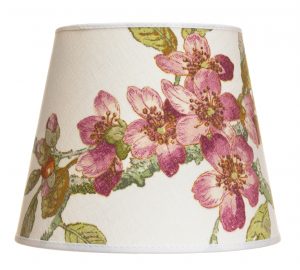 Lampunvarjostin jossa on vaalealla pohjalla roosa kukka kuvio. Varjostin on materiaaliltaan laminoitua kangasta.