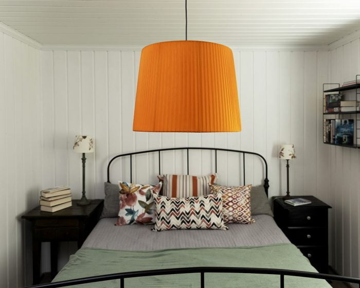 Makuuhuoneen sisustus, jossa on oranssi kattovalaisin.