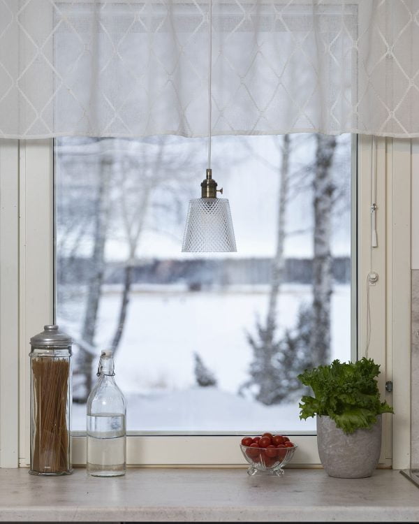 Lasinen riippuvalaisin keittiön ikkunalla.
