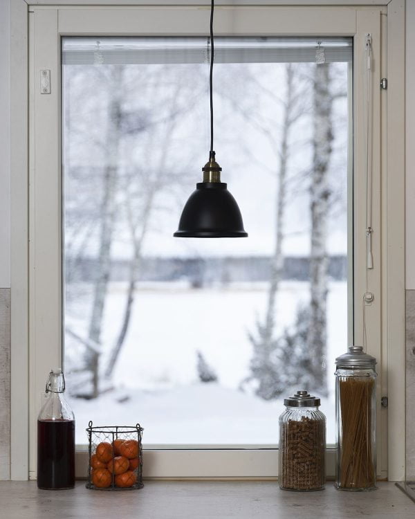 Musta ikkunavalaisin ikkunalla, taustalla luminen maisema.