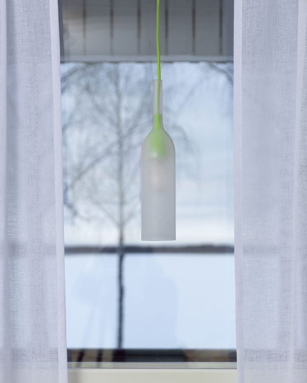 Ikkunavalaisin ikkunalla, taustalla luminen maisema.