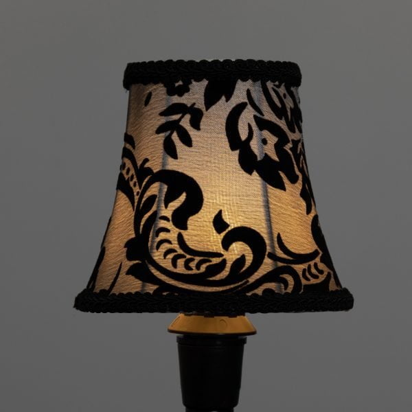 Harmaa lampunvarjostin, jossa on musta kuviointi.