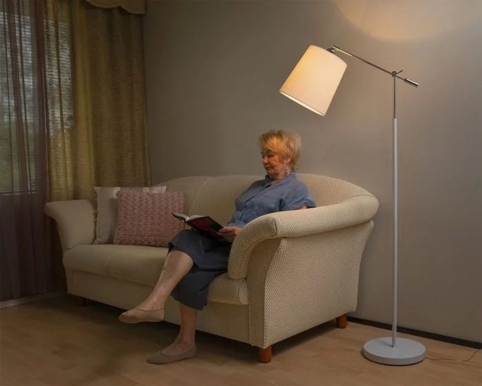 Olohuoneen sisustus jossa valkoinen Park lattiavalaisin, valkoinen Jill kippivarjostin ja vaalea sohva.